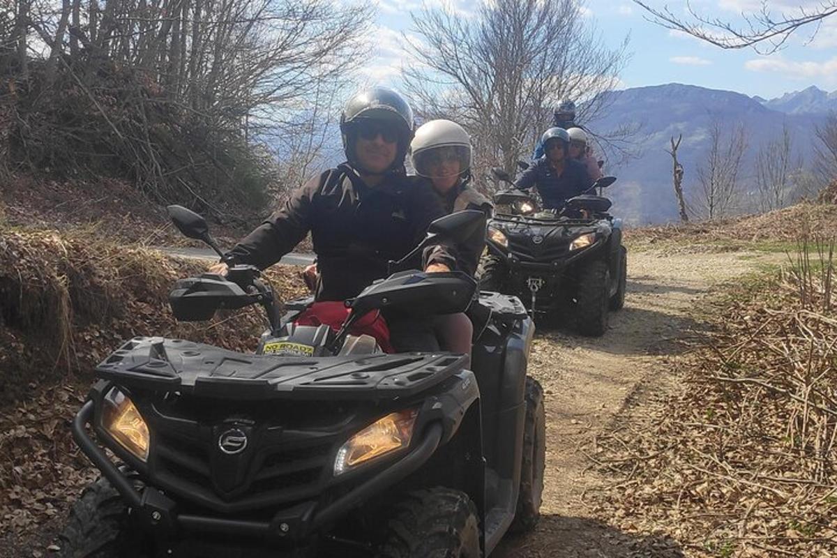 dues persones que viatgen en quads per un camí de terra