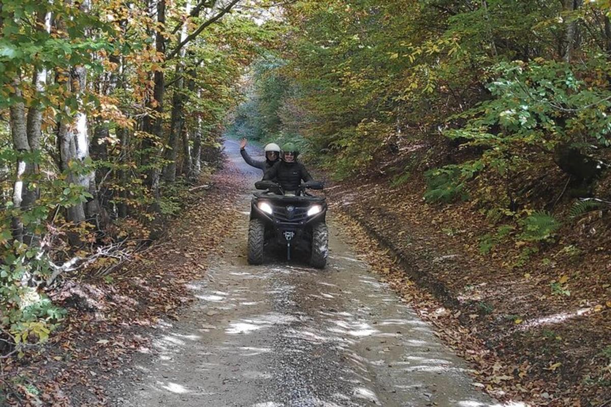dues persones que condueixen una motocicleta per un camí de terra