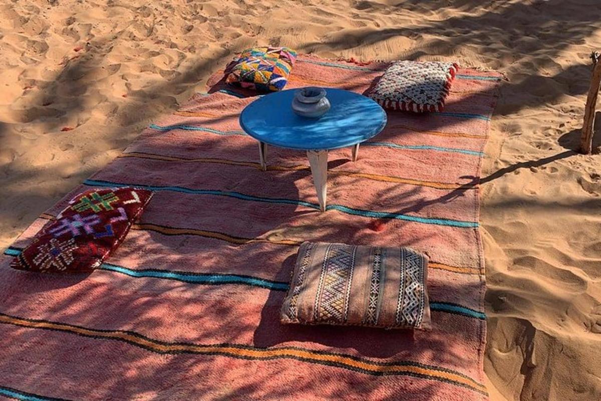 egy takaró a strandon egy asztallal és párnákkal