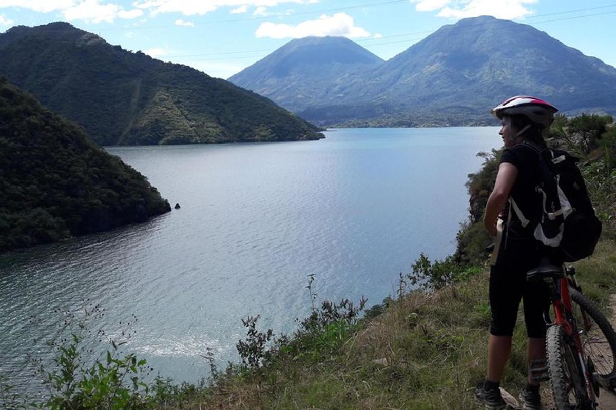 a woman standing on a hill next to a lake