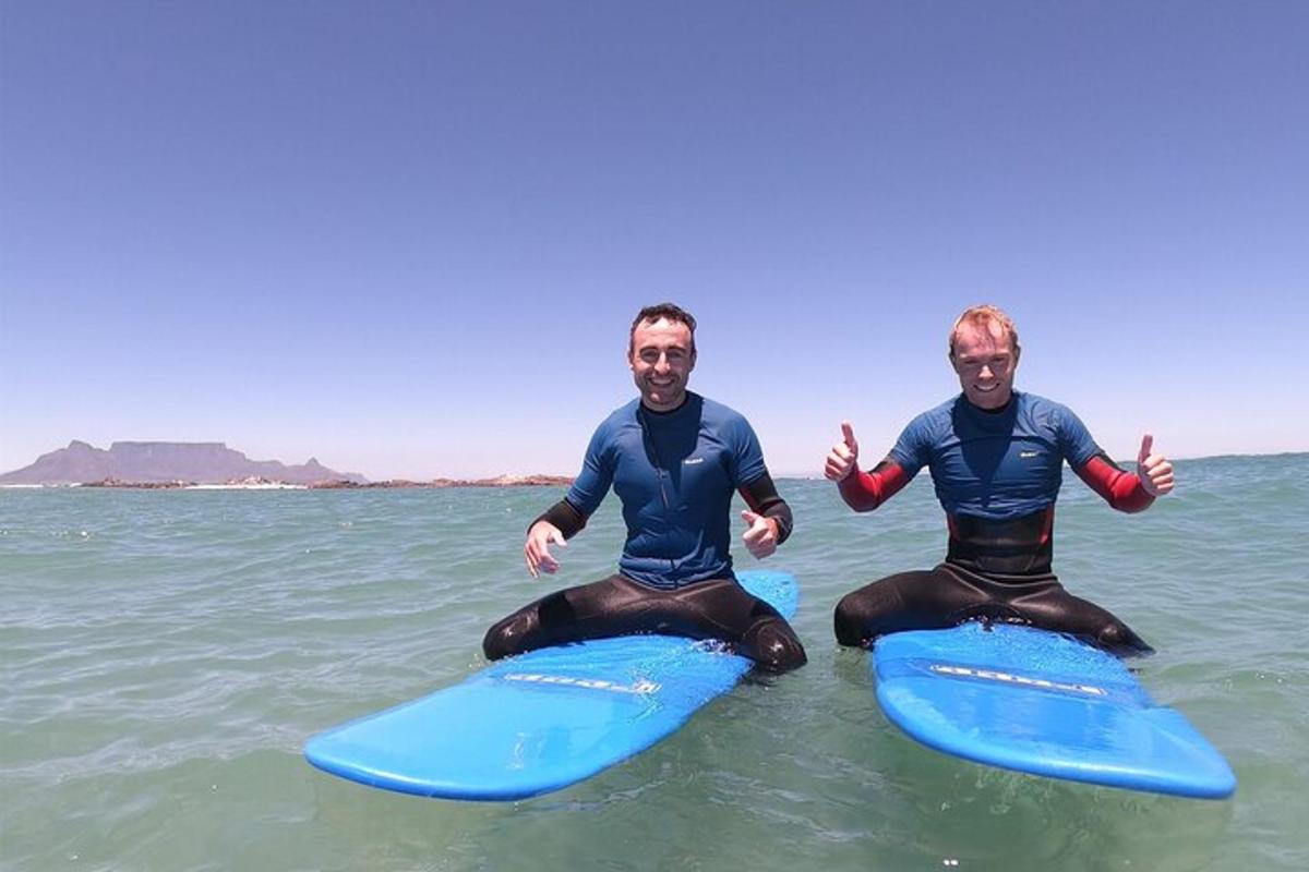 dois homens estão sentados em pranchas de surfe na água