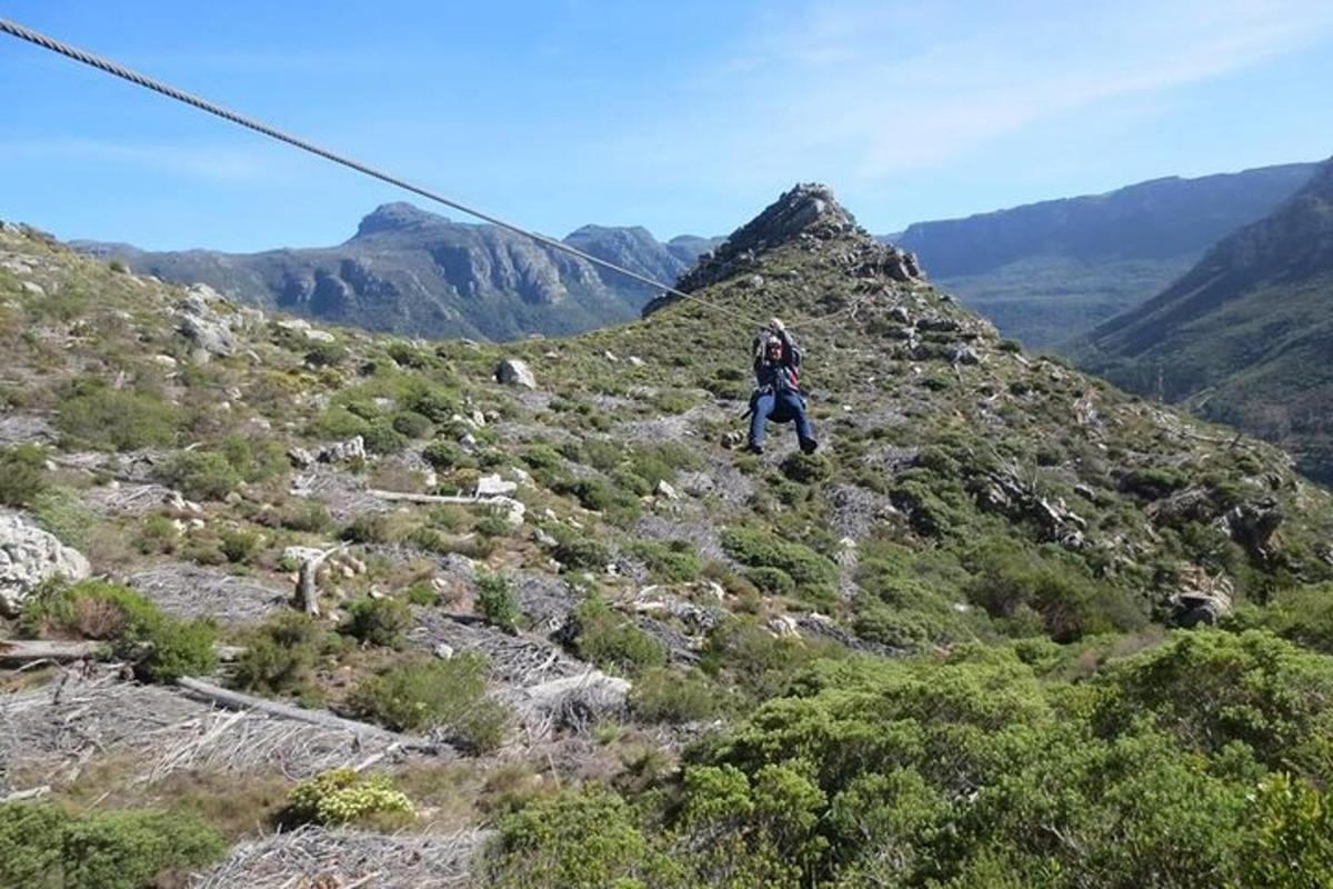 uma pessoa caminhando em uma montanha com uma tirolesa