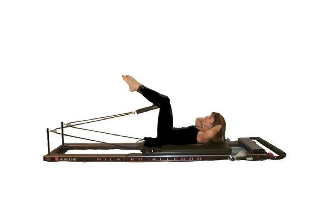 una donna sdraiata su un reformer per pilates
