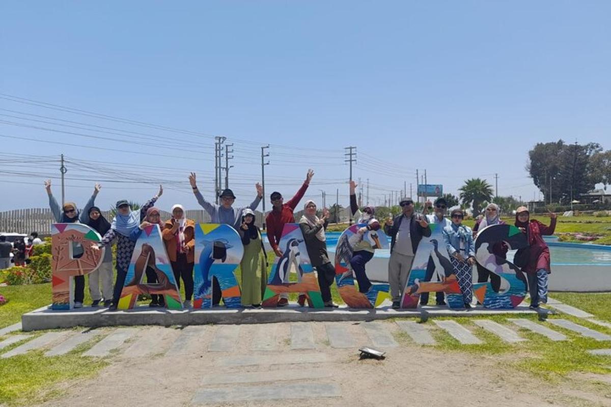 un gruppo di persone in piedi davanti a un murale