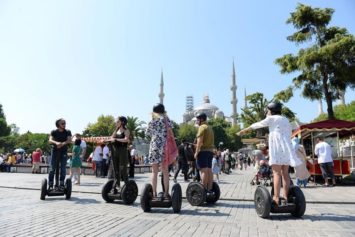 Skupina lidí jedoucích na segwayích před mešitou
