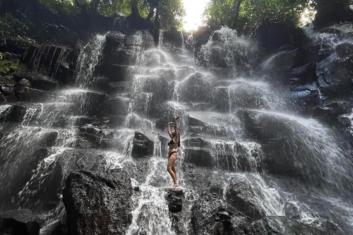 a woman standing on top of a waterfall