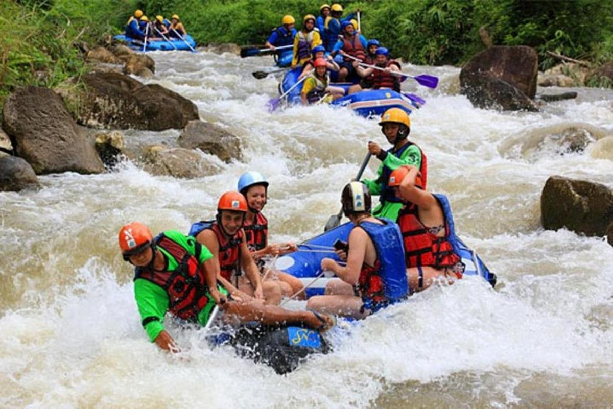 sekelompok orang yang sedang arung jeram di sungai