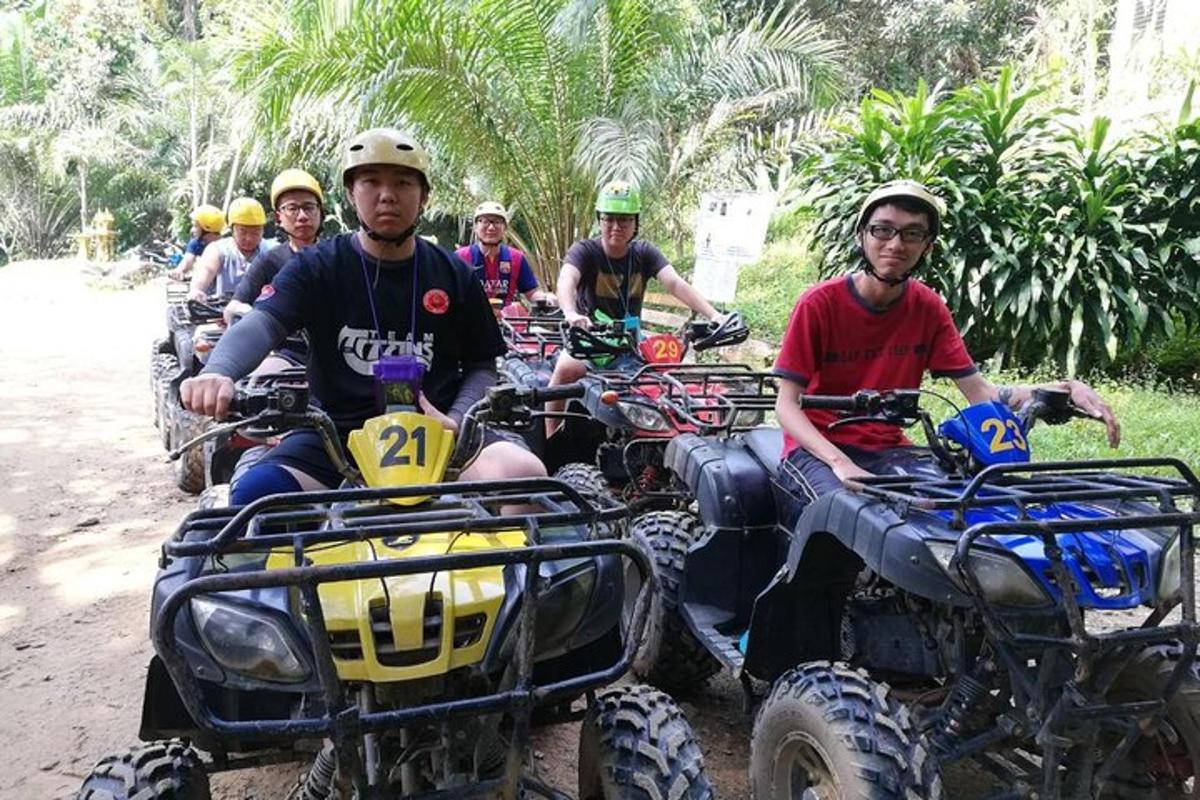 een groep mensen die op een onverharde weg met quads rijden