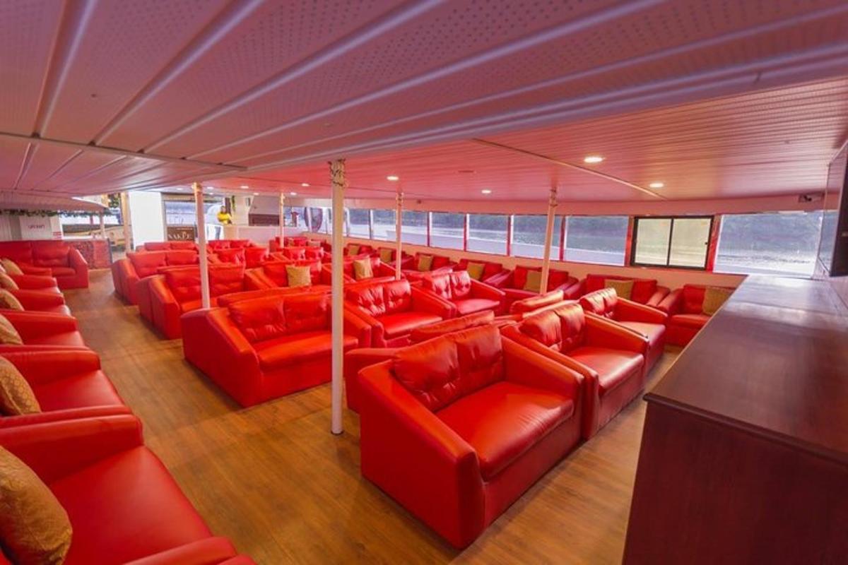 một căn phòng chứa đầy ghế sofa màu đỏ trên thuyền