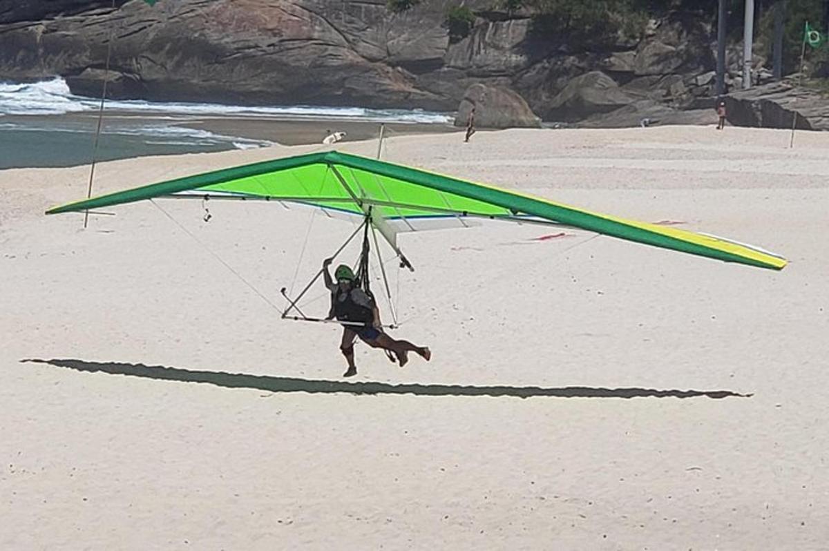 seorang lelaki berlari di bawah layang-layang hijau di pantai