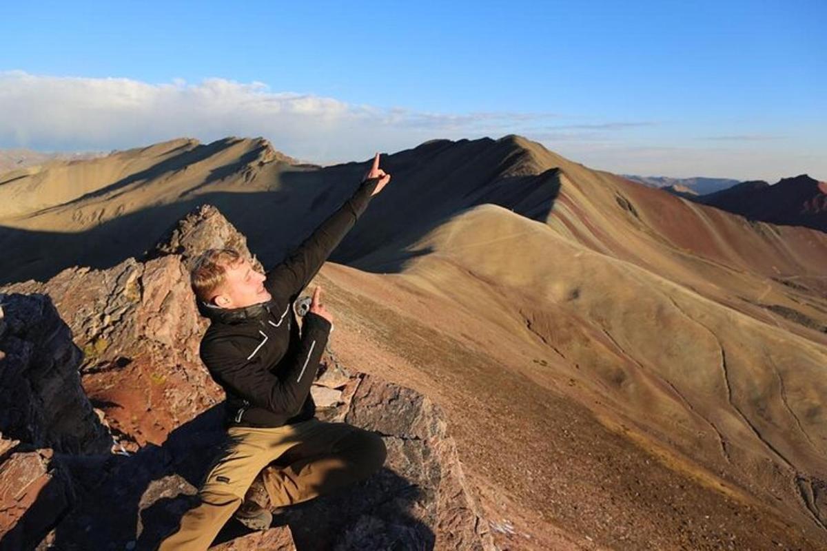 un uomo seduto sulla cima di una montagna
