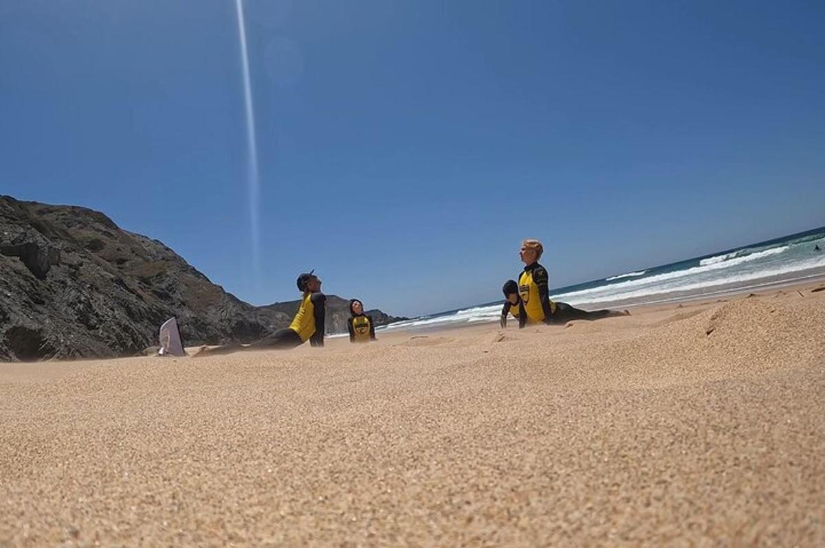 Un grupo de personas con trajes de neopreno en una playa.