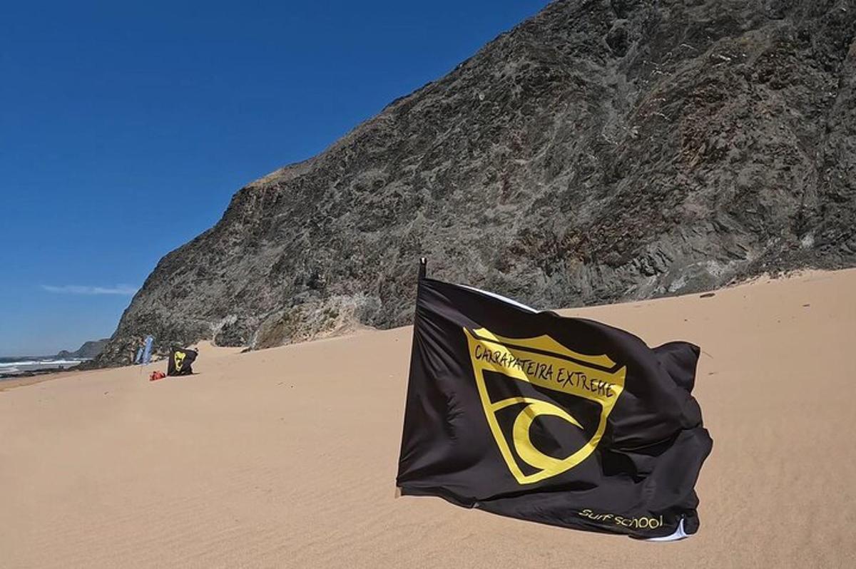 una bandera negra y amarilla en una playa de arena