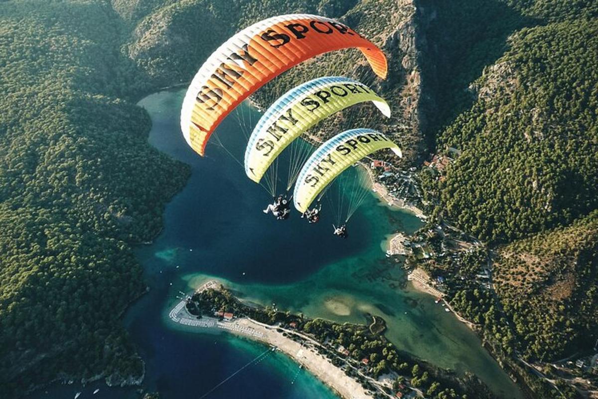 Dva paraglidisti létají nad vodní plochou