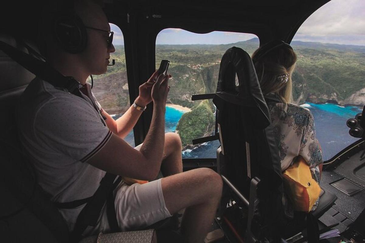 două persoane așezate în cabina unui elicopter