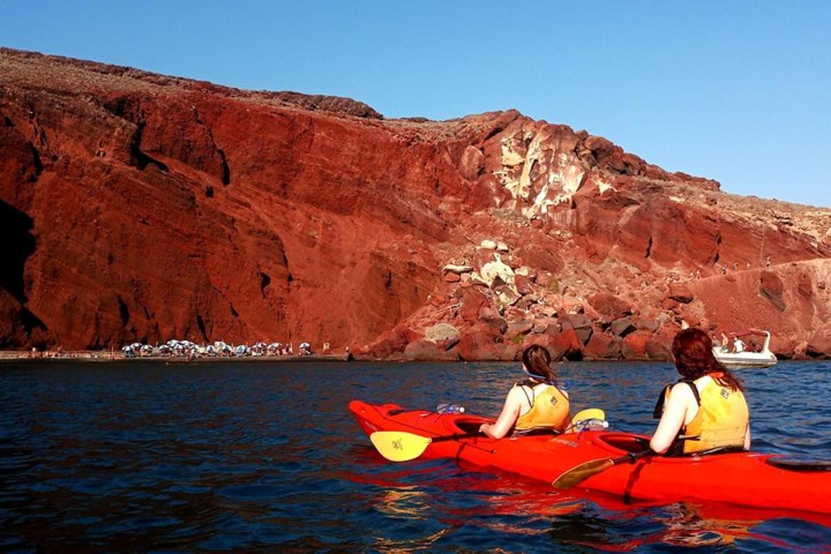 due donne sono sedute su un kayak rosso in acqua