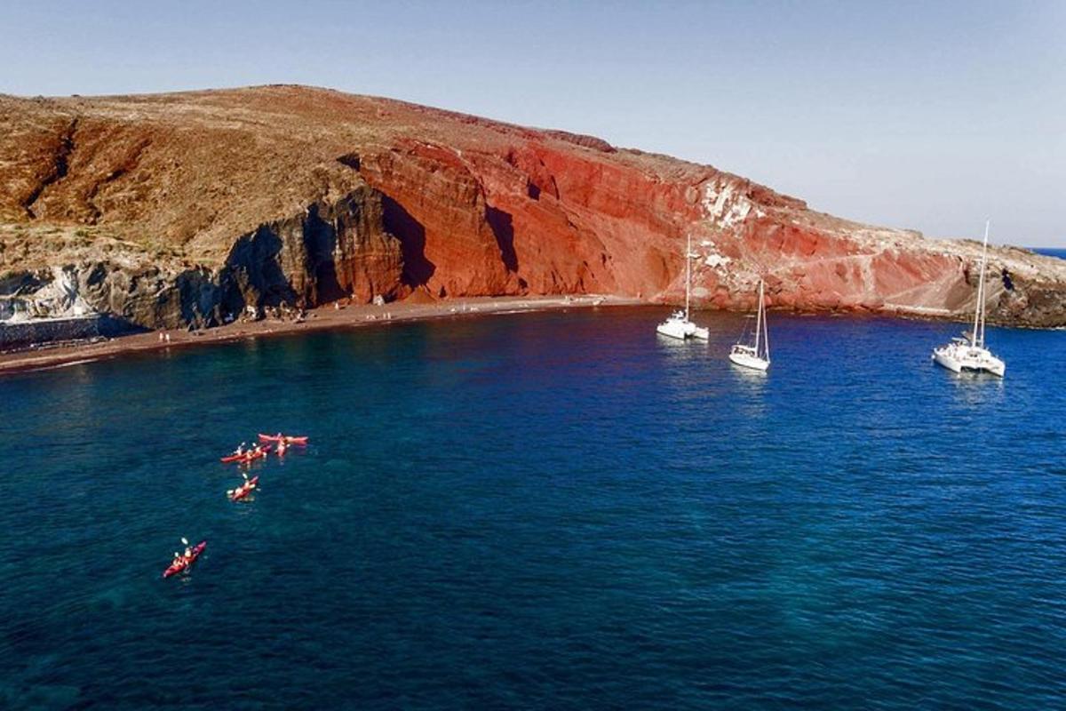 un gruppo di barche in acqua vicino a una spiaggia