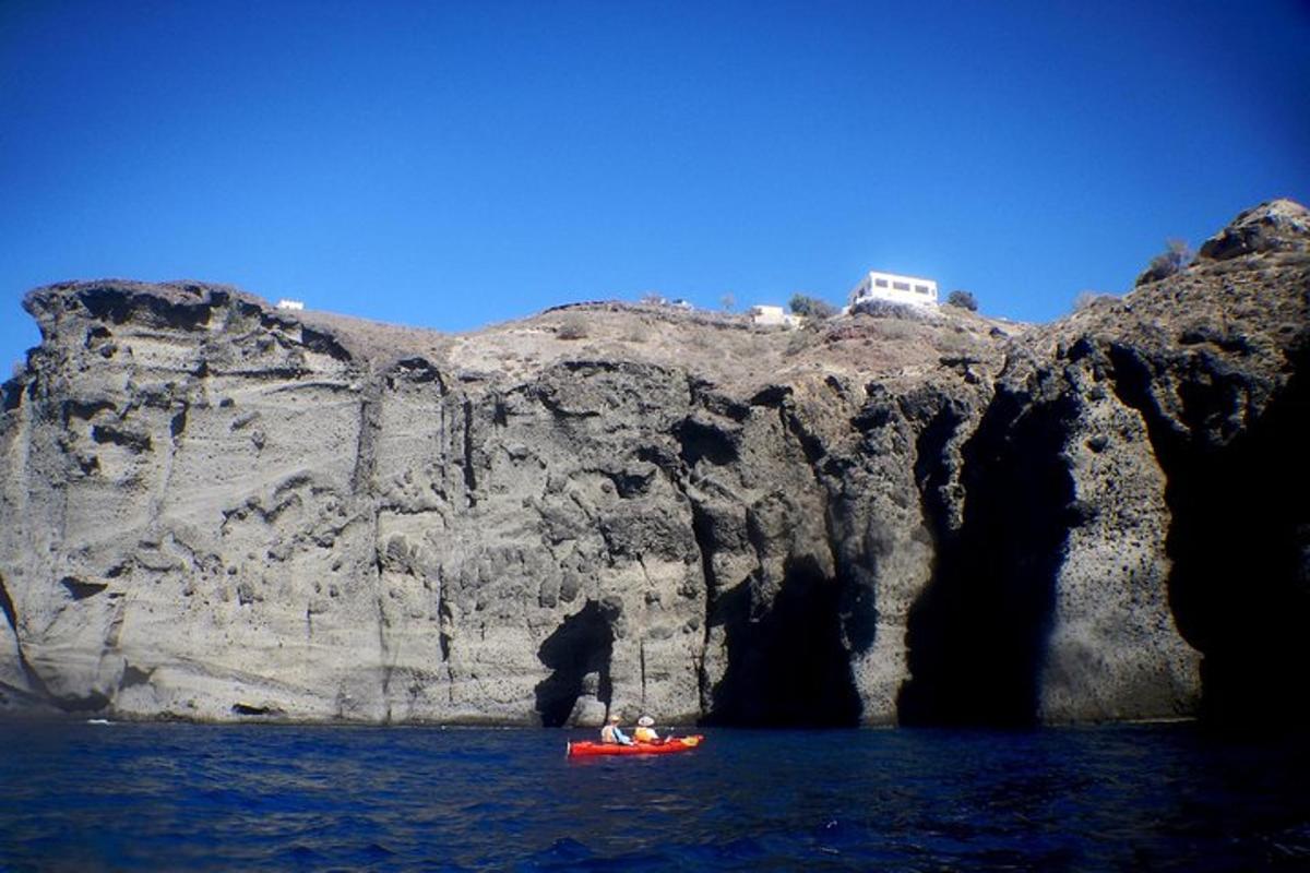 due persone in un kayak rosso di fronte a una montagna