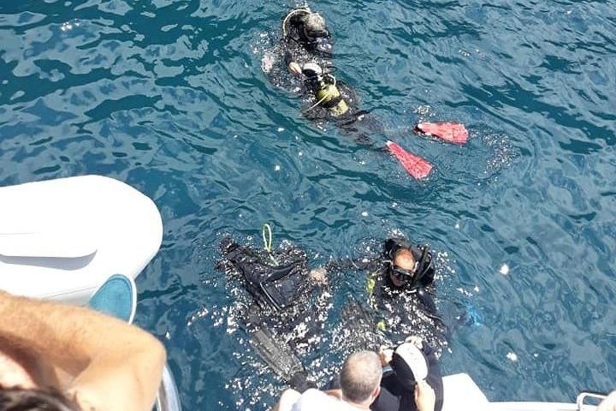 eine Gruppe von Menschen im Wasser neben einem Boot