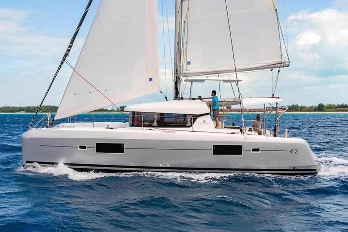 ein weißes Segelboot im Wasser mit einem Mann darauf