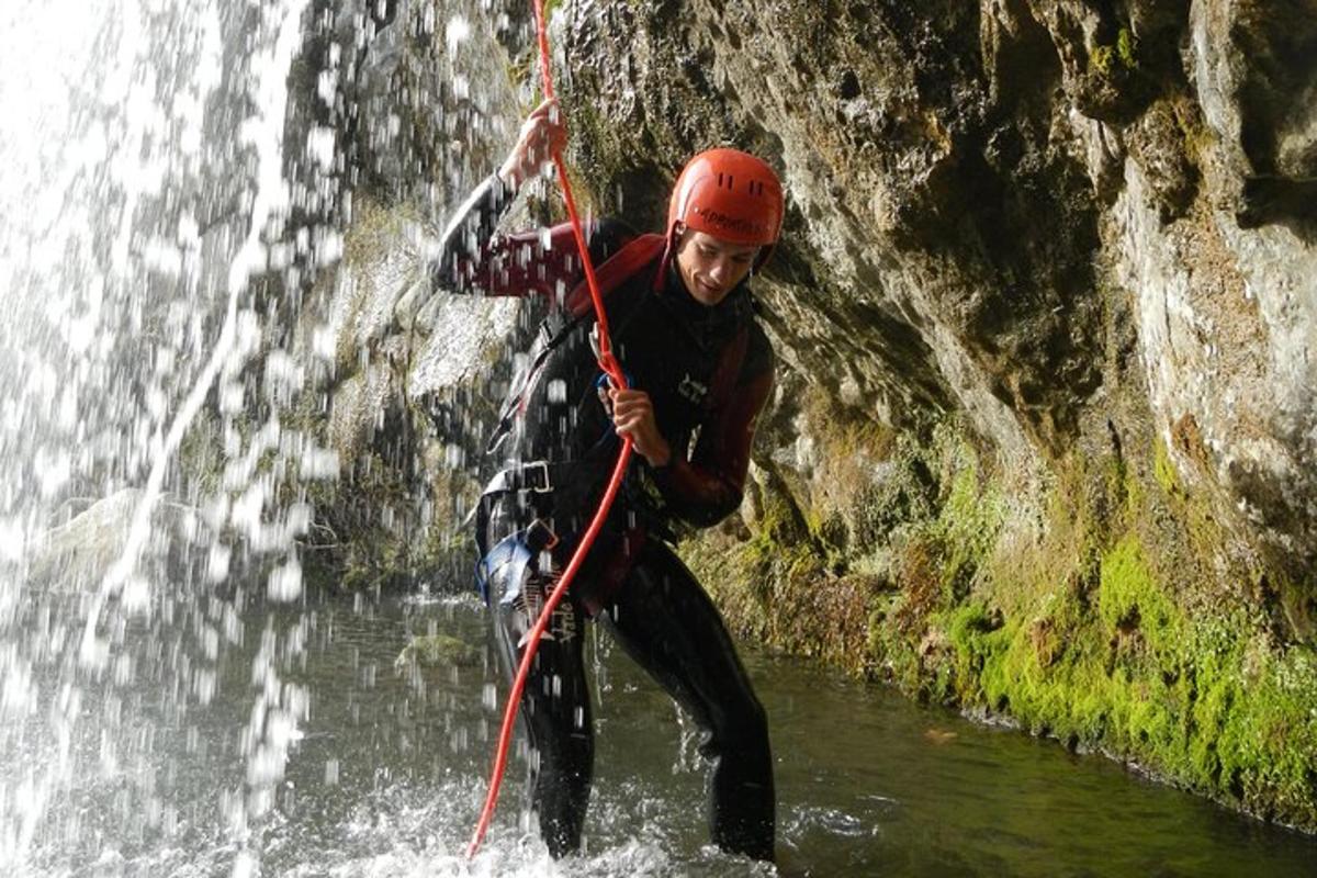 un home a l'aigua davant d'una cascada