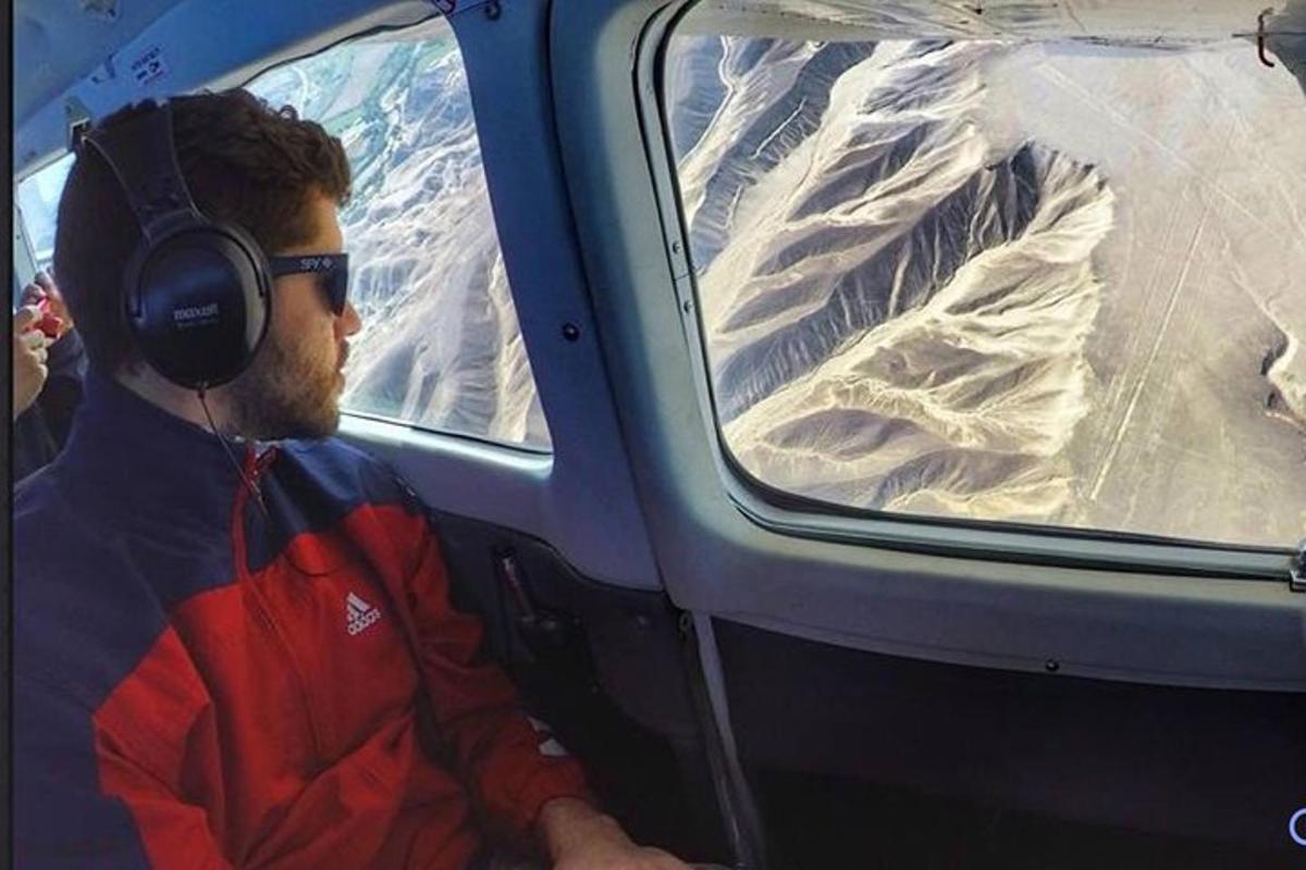 kõrvaklappidega mees istub helikopteri istmel