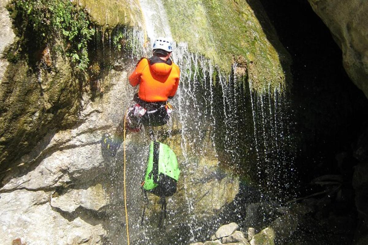 un home està dret al mig d'una cascada