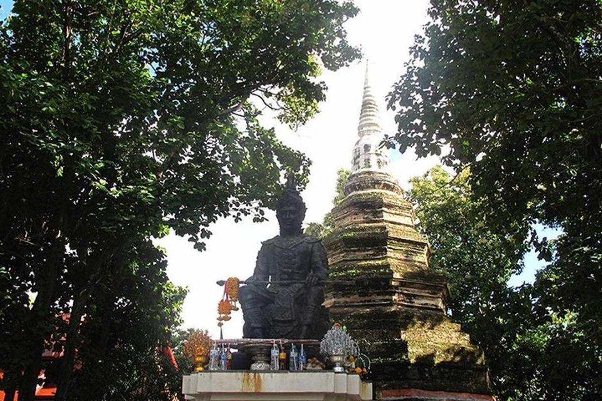 một bức tượng trước một tòa nhà có tháp
