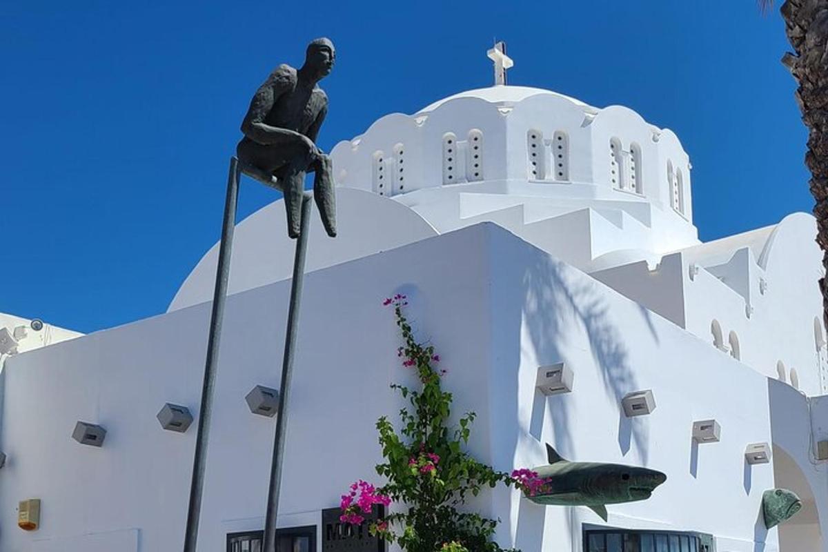 patung seorang pria yang duduk di atas gereja