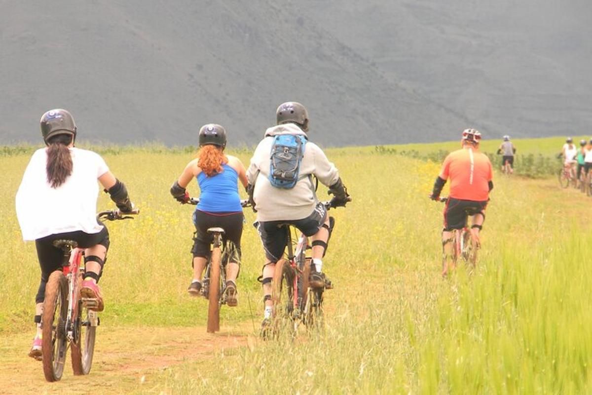a group of people riding bikes down a dirt road