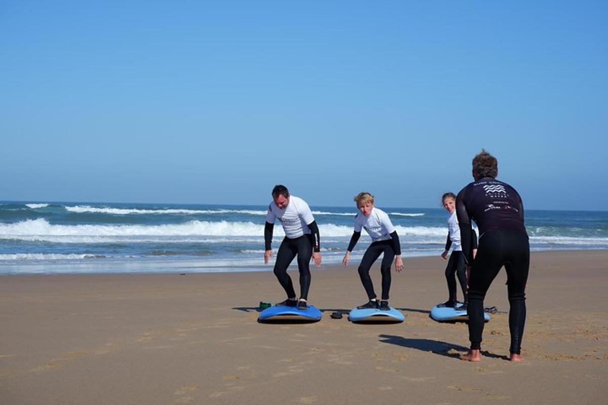 isang grupo ng mga tao na nakatayo sa mga surfboard sa beach