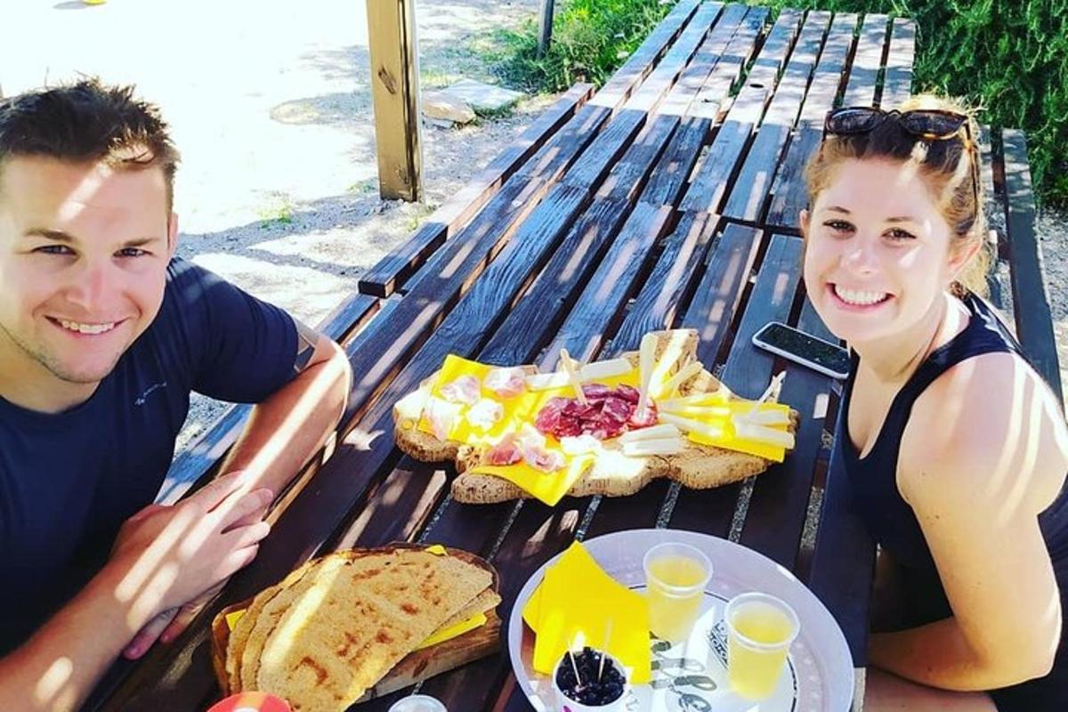 a man and a woman sitting at a picnic table with food