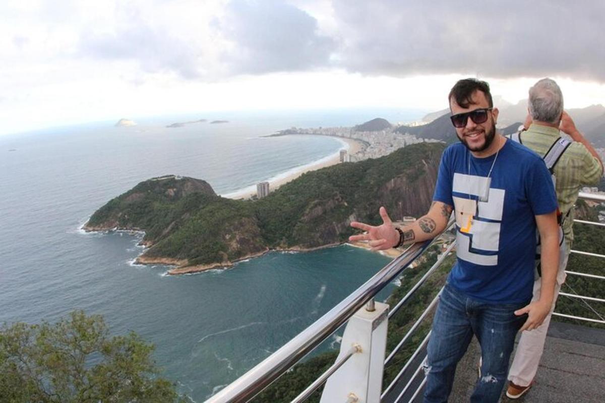 moški, ki stoji na vrhu gore s pogledom na ocean