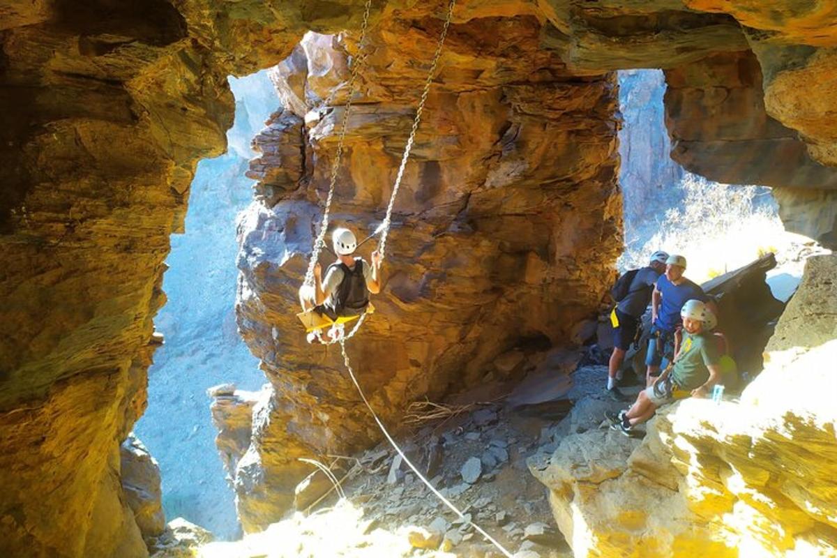 un gruppo di persone è su una corda doppia in una grotta