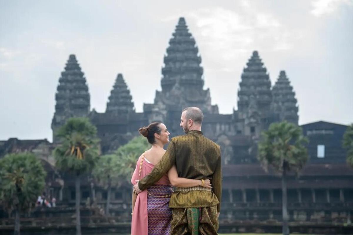 seorang lelaki dan seorang wanita berdiri di hadapan sebuah bangunan