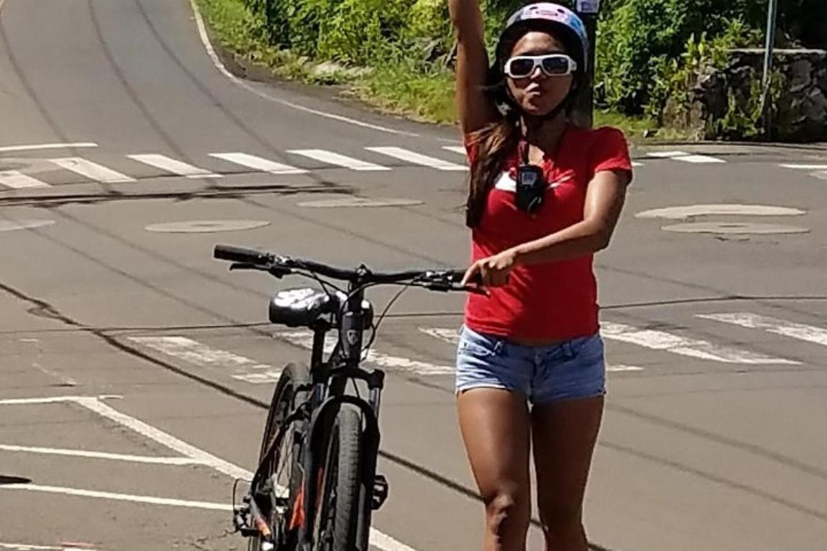 una donna in piedi accanto a una bicicletta su una strada