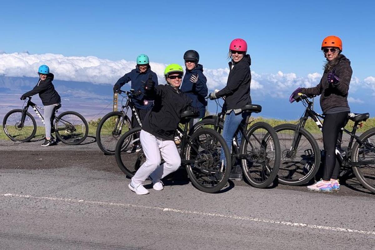 un gruppo di persone in posa con le loro biciclette su una strada