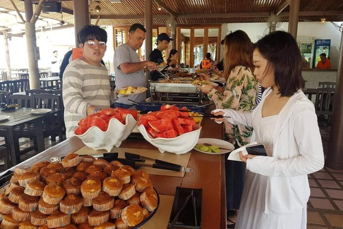 sekelompok orang berdiri di sekitar konter dengan makanan