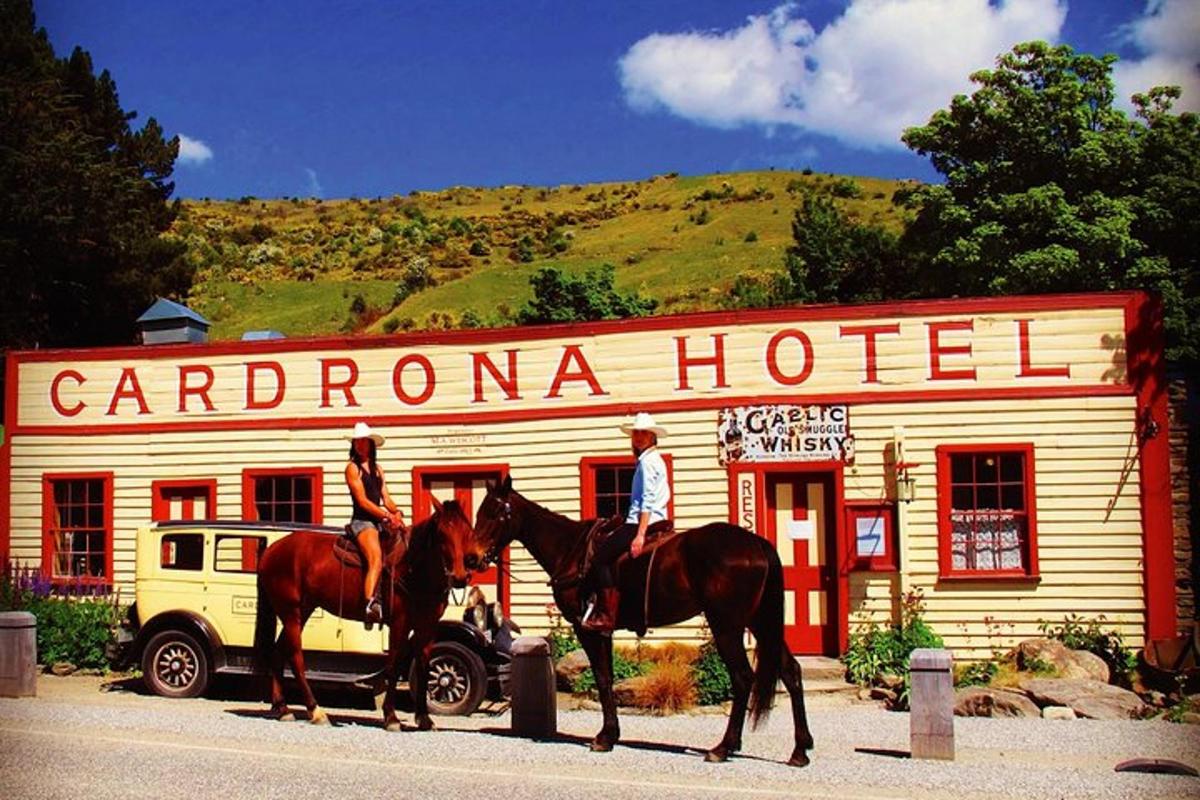 duas pessoas a cavalo em frente a um hotel em Carleton