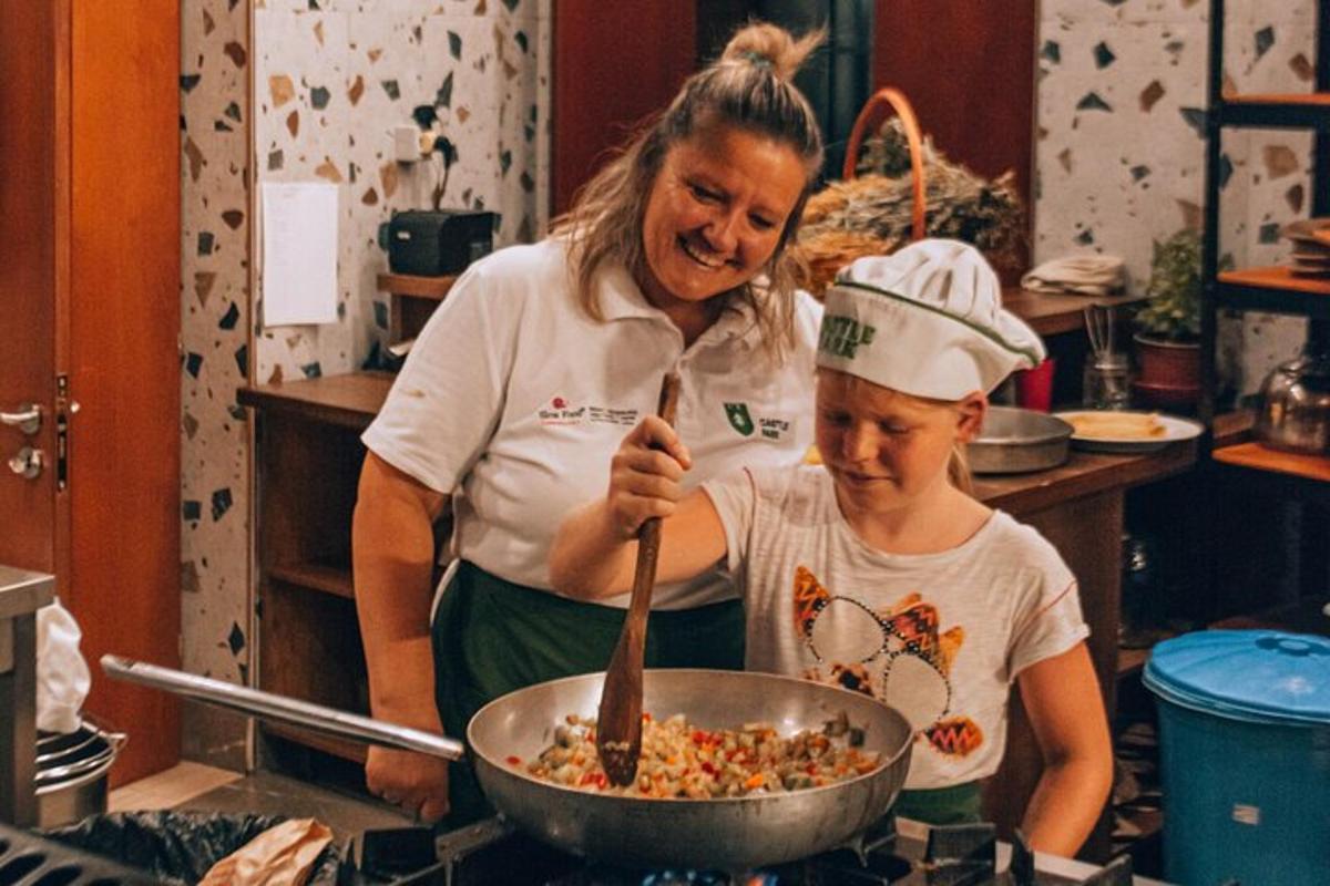 una donna e un bambino preparano il cibo in una padella
