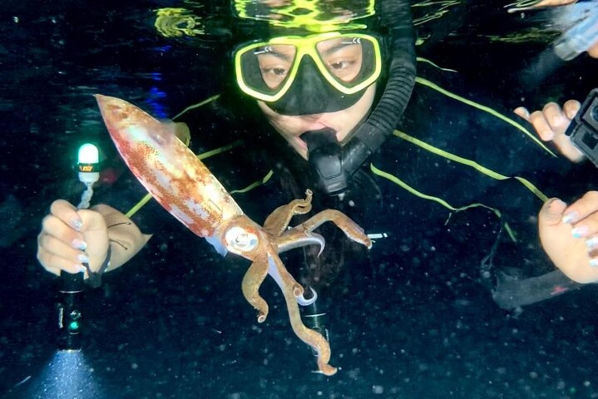 Un hombre con una máscara de buceo sosteniendo un pulpo