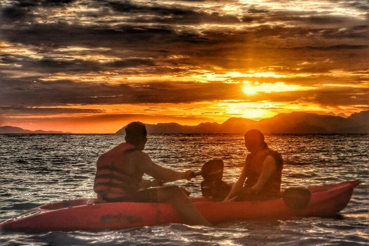 Un grupo de personas sentadas en un kayak en el agua al atardecer.