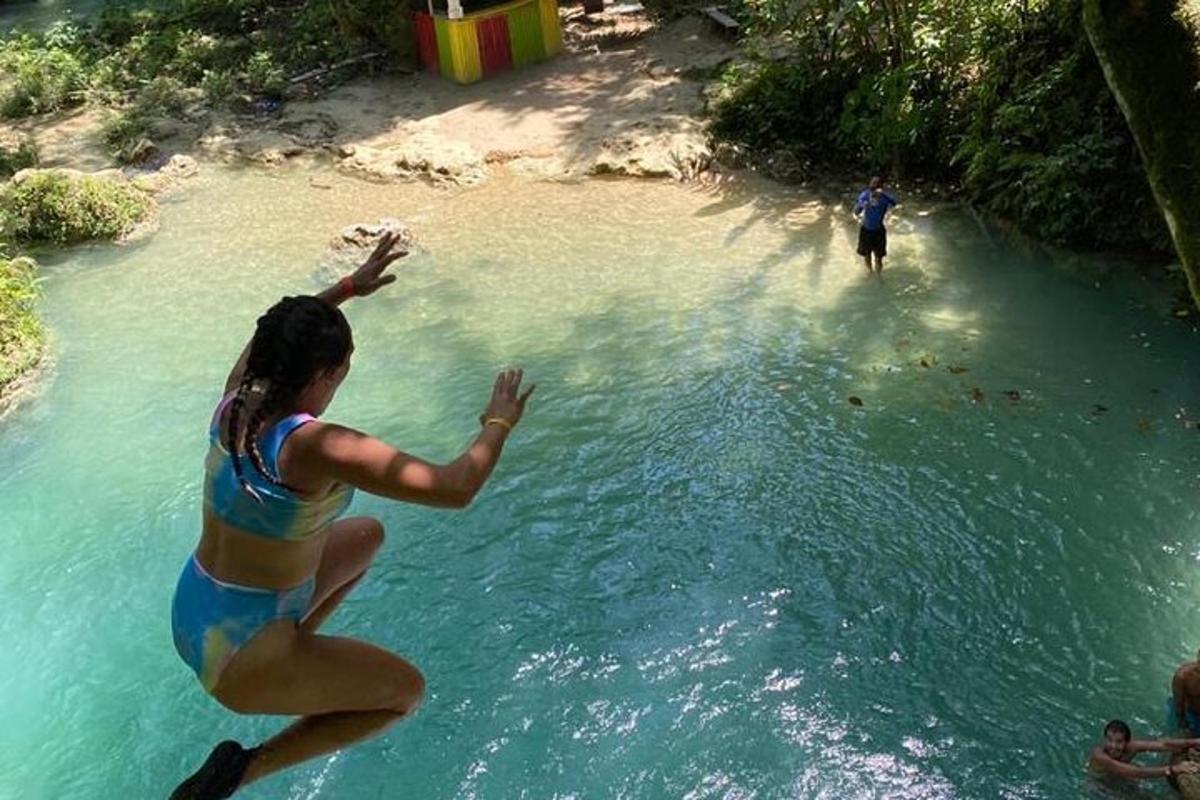 una mujer saltando a un cuerpo de agua