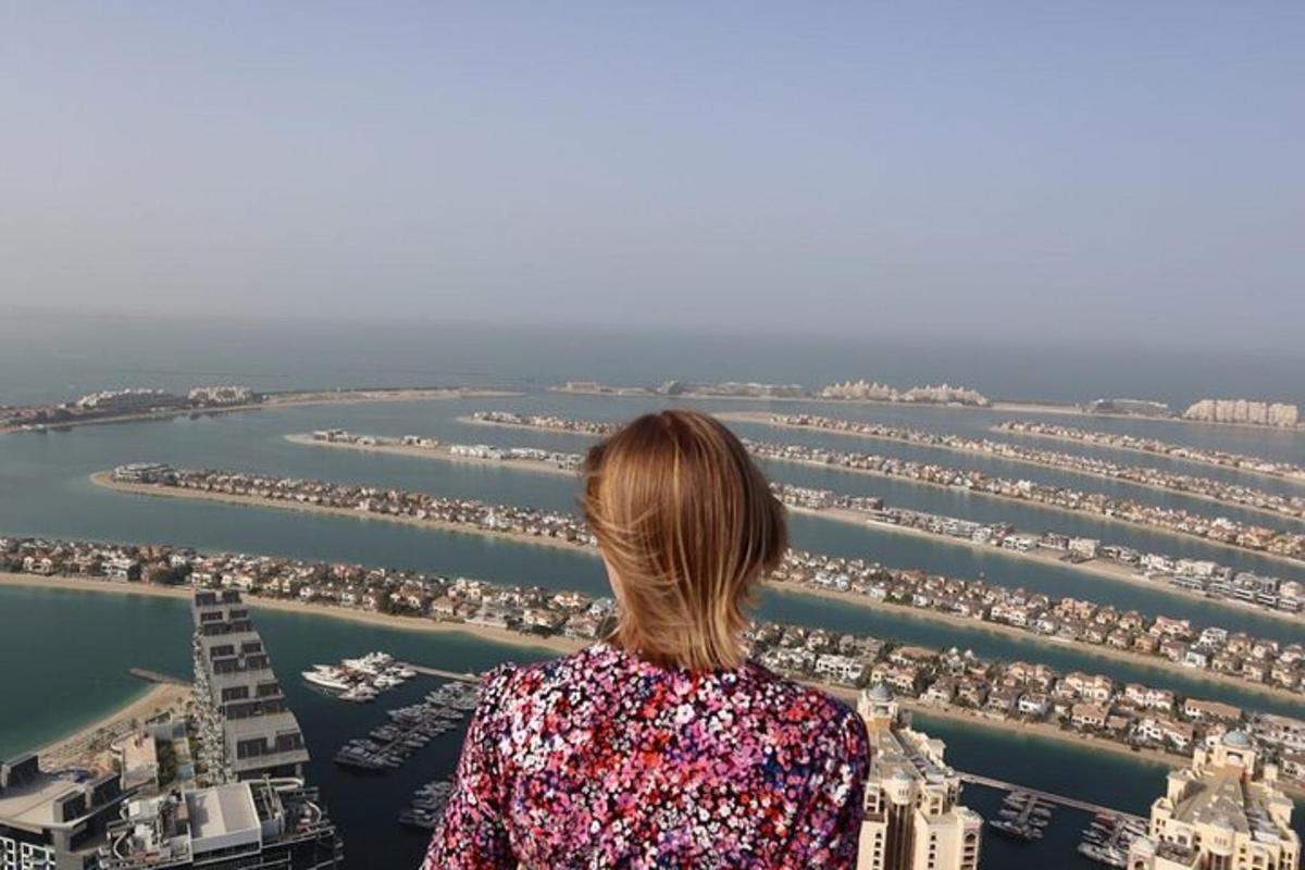 a woman standing on top of a tower looking at a harbor