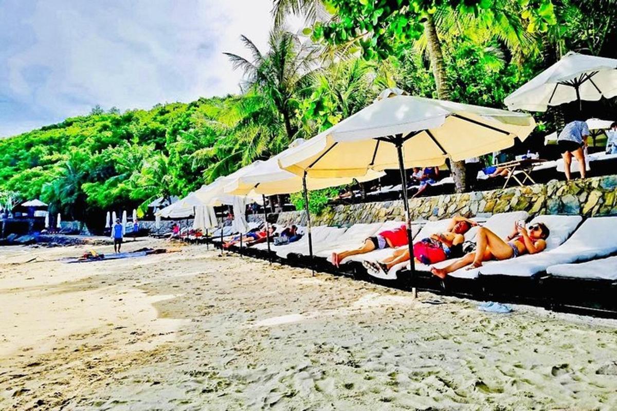 một nhóm người nằm trên bãi biển dưới những chiếc ô