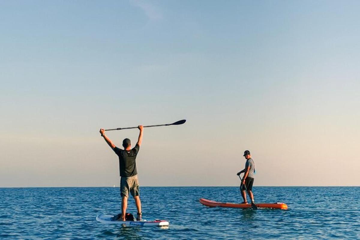 due uomini sono in piedi su tavole da surf nell'oceano