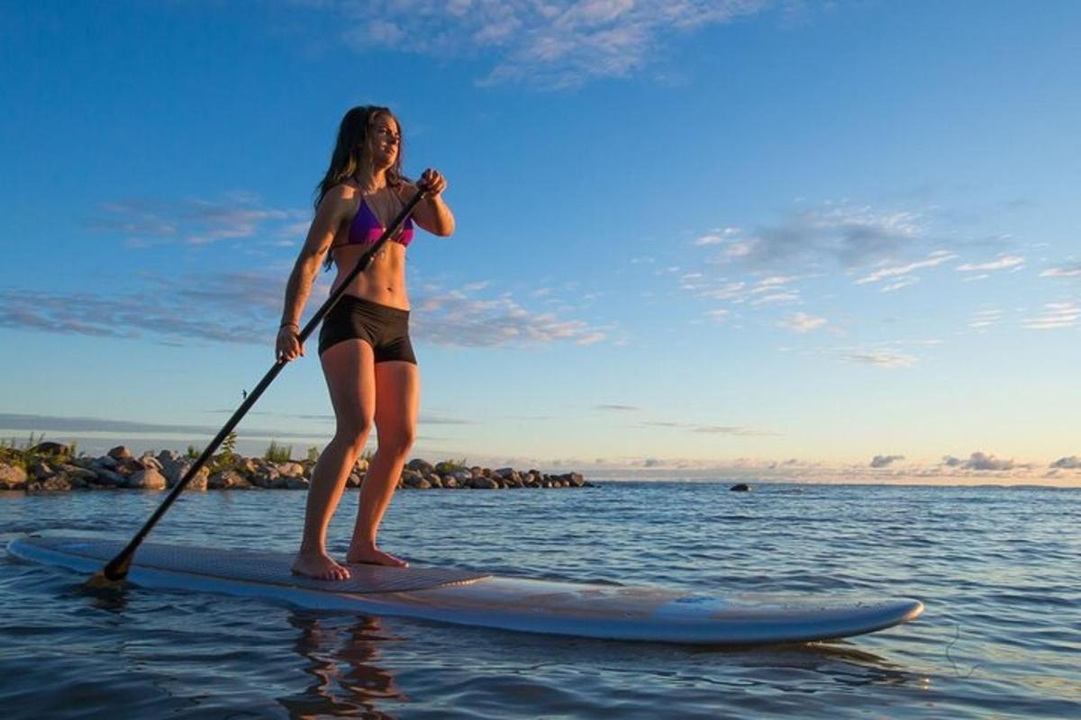 una donna in piedi su una tavola da paddle in acqua