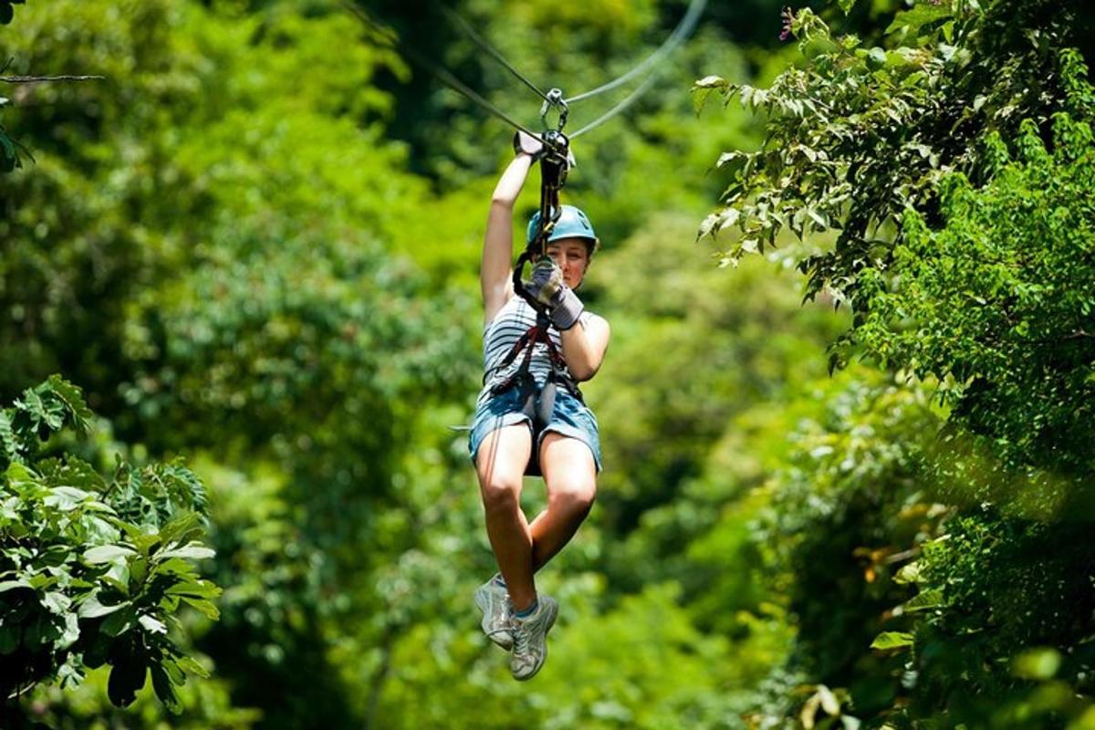 ženska se vozi po ziplineu med drevesi