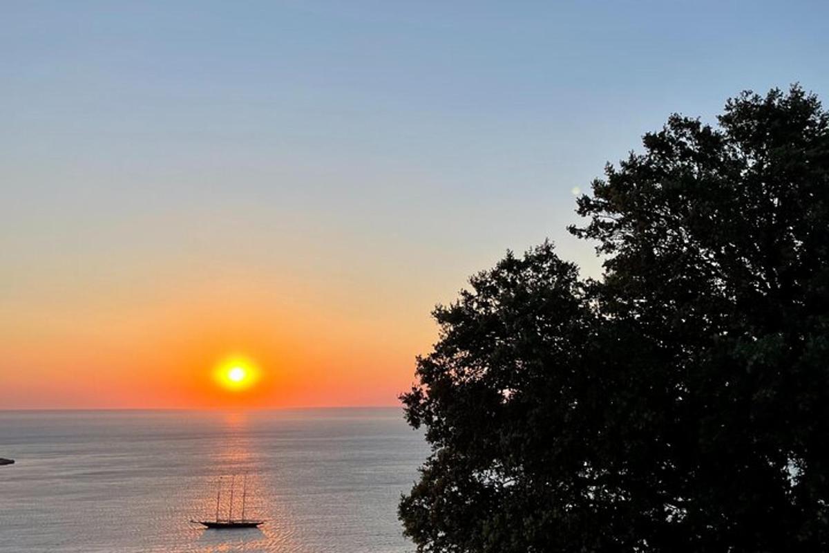purjevene meressä auringonlaskun aikaan