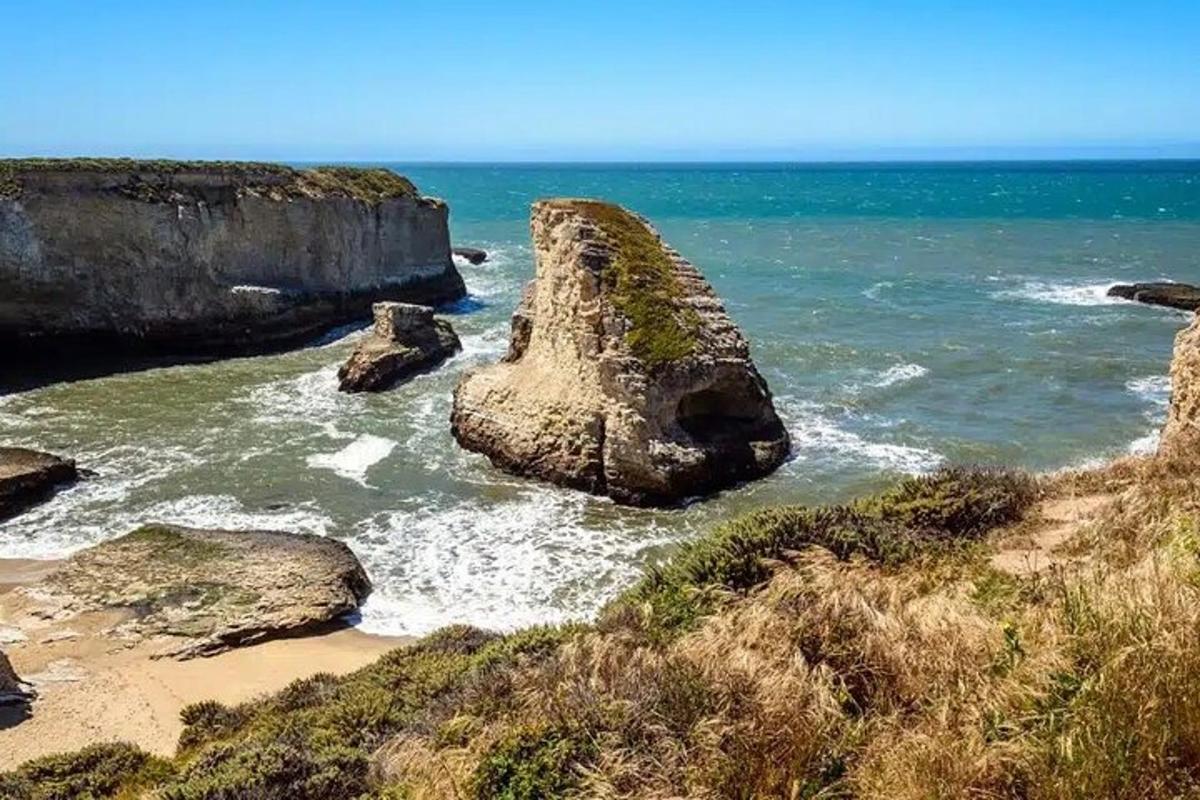 a large rock in the water on a beach